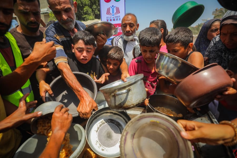 Palestinians receive meals from volunteers in Gaza City, August 10, 2025. (Photo: Ali Hassan/Flash90)