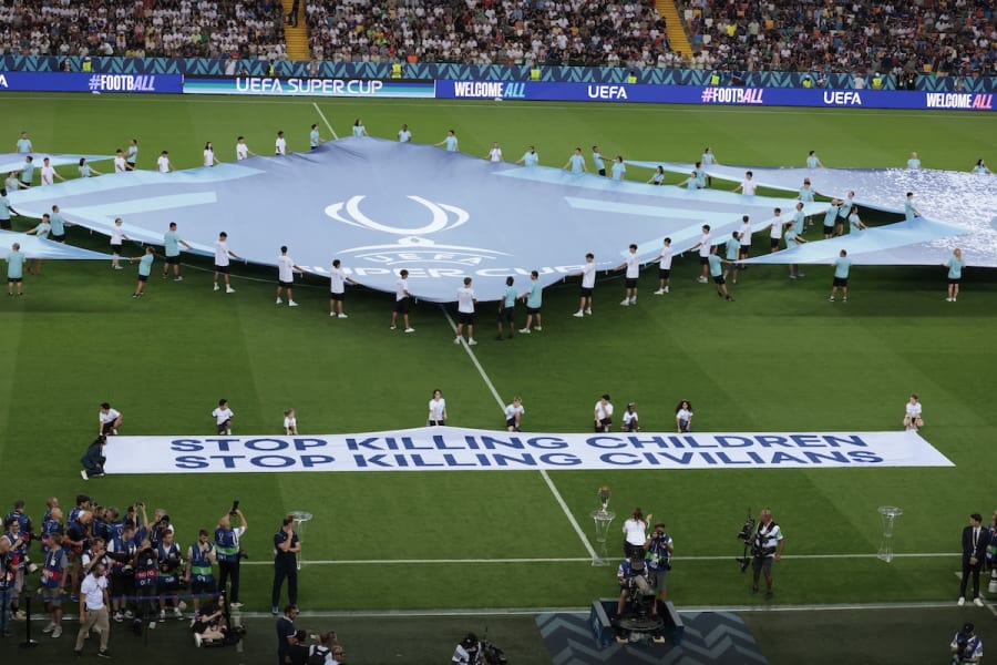 UEFA Super Cup - Final - Paris St Germain v Tottenham Hotspur - Bluenergy Stadium, Udine, Italy - August 13, 2025. Nine children who are refugees in Italy from different conflict zones, Afghanistan, Iraq, Nigeria, Palestine and Ukraine, display a banner saying "Stop Killing Children" (Photo: Reuters)