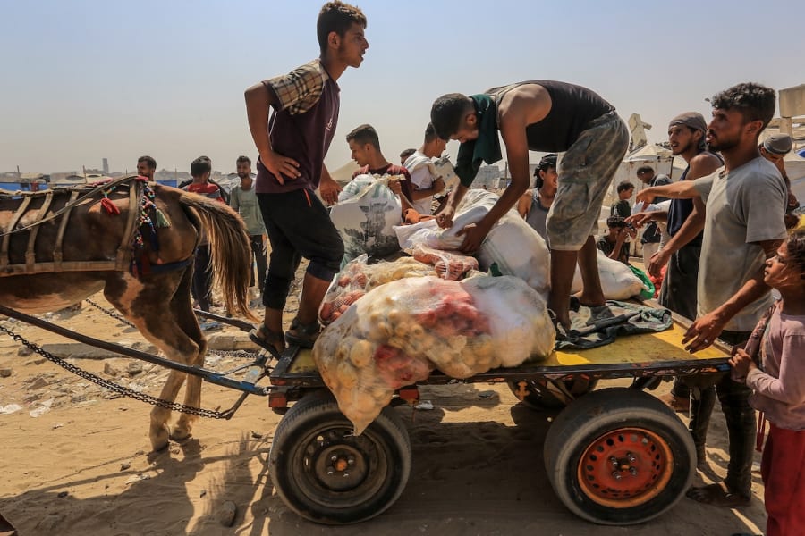 Palestinians carry humanitarian aid in Rafah, in the southern Gaza Strip, Aug. 14, 2025. (Photo: Abed Rahim Khatib/Flash90)