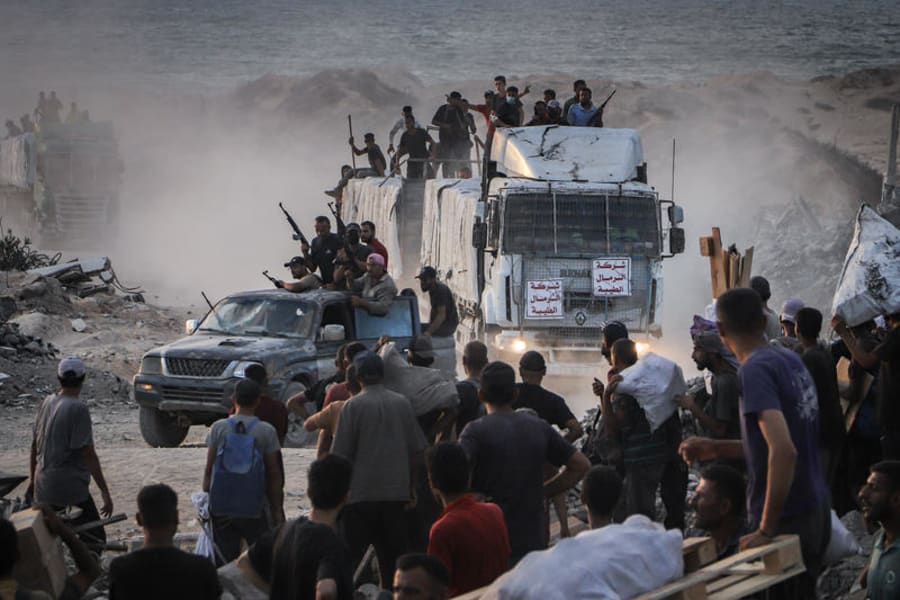 Armed Palestinians sit on trucks carrying humanitarian aid near the Zikim border crossing between Israel and Beit Lahia in the northern Gaza Strip, Aug. 18, 2025. (Photo: Khalil Kahlout/ Flash90