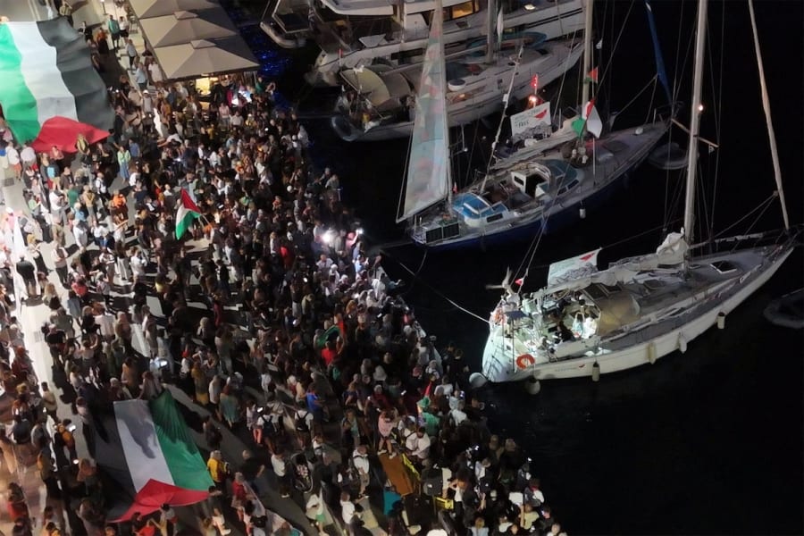 Une capture d'écran d'une vidéo prise par un drone montre des personnes se rassemblant dans le port d'Ermoupolis lors du départ de deux voiliers, Electra et Oxygen, faisant partie de la flottille Global Sumud visant à atteindre Gaza et à briser le blocus naval d'Israël, sur l'île de Syros, en Grèce, le 14 septembre 2025. (Photo : REUTERS/Giorgos Solaris)