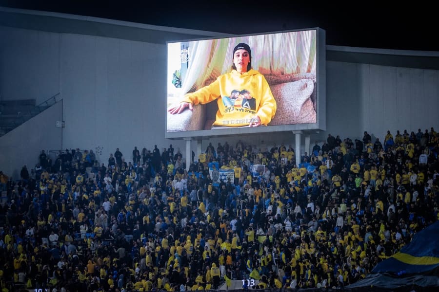 Released hostage Emily Damari speaks on a large screen during the Israeli Premier League match between Beitar Jerusalem and Maccabi Tel Aviv F.C. at the Bloomfield Stadium in Tel Aviv, February 3, 2025. (Photo: Oren Ben Hakoon/Flash90)