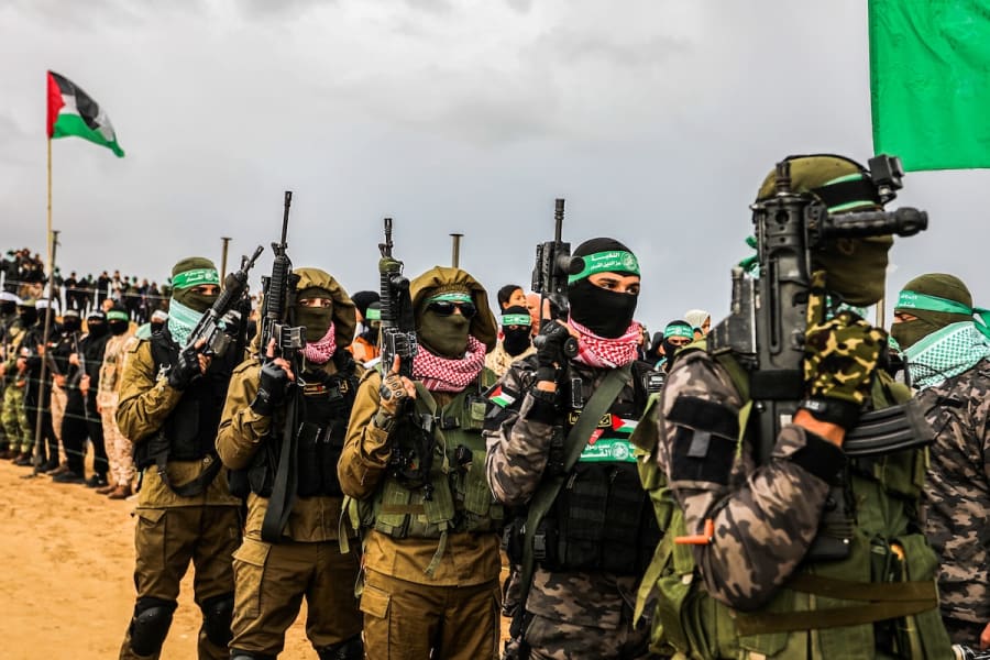 Des membres des Brigades Al-Qassam et des Palestiniens attendent la remise des corps de quatre otages israéliens décédés à la Croix-Rouge, dans le cadre de l'accord de cessez-le-feu entre Israël et le Hamas, à Khan Younis, le 20 février 2025. (Photo : Abed Rahim Khatib/Flash90)