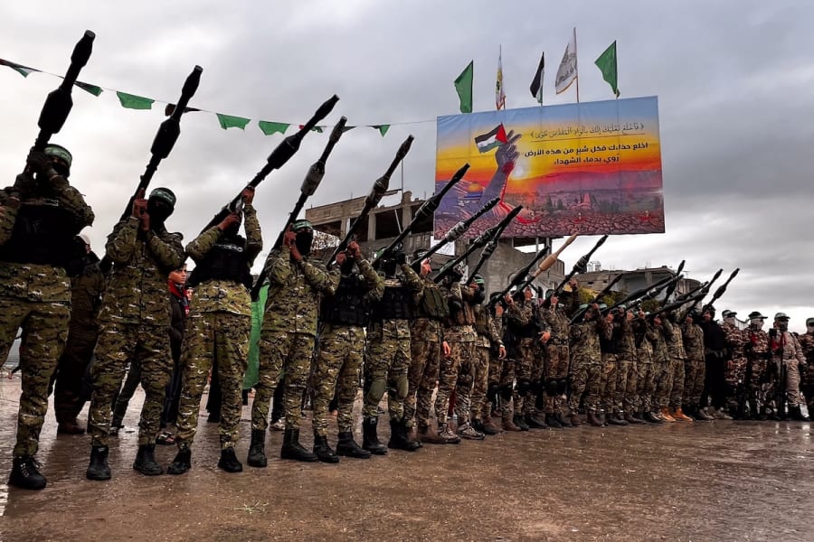 Des membres des Brigades Al-Qassam montent la garde alors que des Palestiniens attendent la remise d'otages israéliens à la Croix-Rouge, dans le cadre de l'accord de cessez-le-feu entre Israël et le Hamas, à Rafah, le 22 février 2025. (Photo : Saeed Mohammed/Flash90)