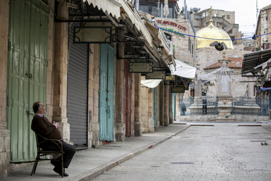 A restaurant owner in the Old city of Jerusalem sits outside his empty shop near to the Church of the Holy Sepulcher on July 30, 2020. (Photo credit: Olivier Fitoussi/Flash90)