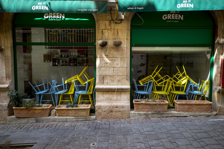 Stacked chairs in a closed salad bar on Jaffa Street in downtown Jerusalem on September 30, 2020, during a nationwide lockdown. (Photo by Olivier Fitoussi/Flash90)