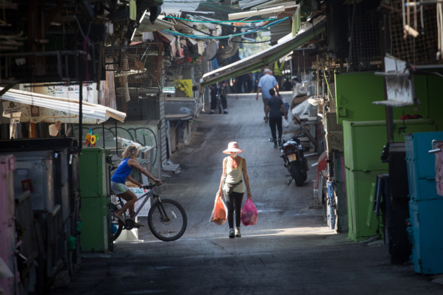 Israelis wear protective face masks as they walk through the closed down Carmel market, in Tel Aviv, during a nationwide lockdown, on October 26, 2020. (Photo:Miriam Alster/FLASH90)