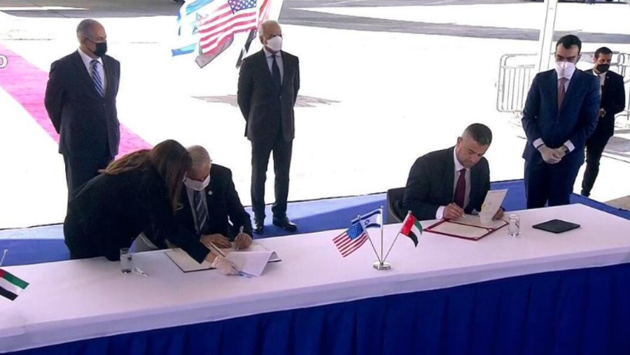 Prime Minister Benjamin Netanyahu (left rear) watches as the UAE delegation sign 4 new agreements on cooperation at Ben Gurion Airport, Oct. 20, 2020 (Photo: GPO)