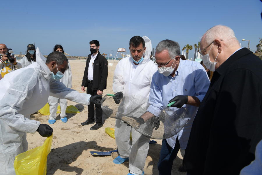 President Reuven Rivlin visits a beach to survey the damage after a massive oil spill on Israel's coast in February 2021. (Photo: Amos Ben Gershom/GPO)