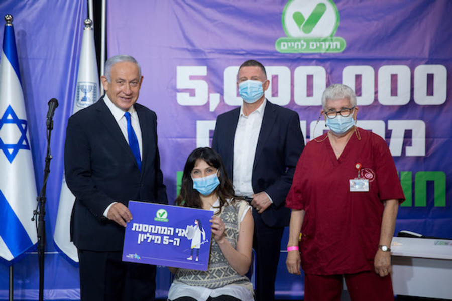 Israeli Prime Minister Benjamin Netanyahu and Health Minister Yuli Edelstein seen during a visit at a COVID-19 vaccination center in Tel Aviv, with the 5 millionth Israeli who received a vaccination, on March 08, 2021. (Photo: Miriam Alster/Flash90)