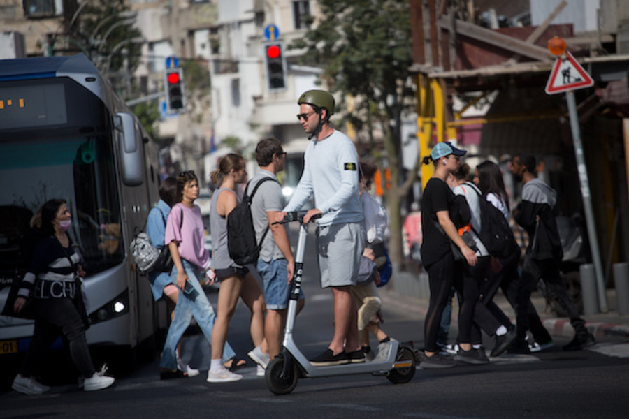 Israelis walk on the streets of Tel Aviv without wearing protective face masks, as Israel lifts the restrictions on wearing a mask outdoors. April 28, 2021. (Photo: Miriam Alster/FLASH90)