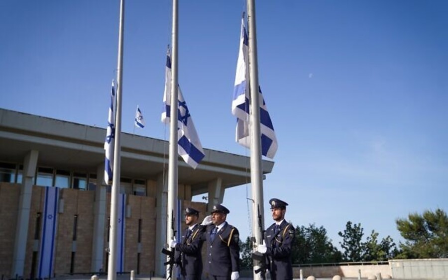 The Knesset Guard lowers flags to half-mast outside the Knesset in Jerusalem as a national day of mourning begins for victims of the Meron tragedy, May 2, 2021. (Photo: Noam Moskowitz/Knesset)