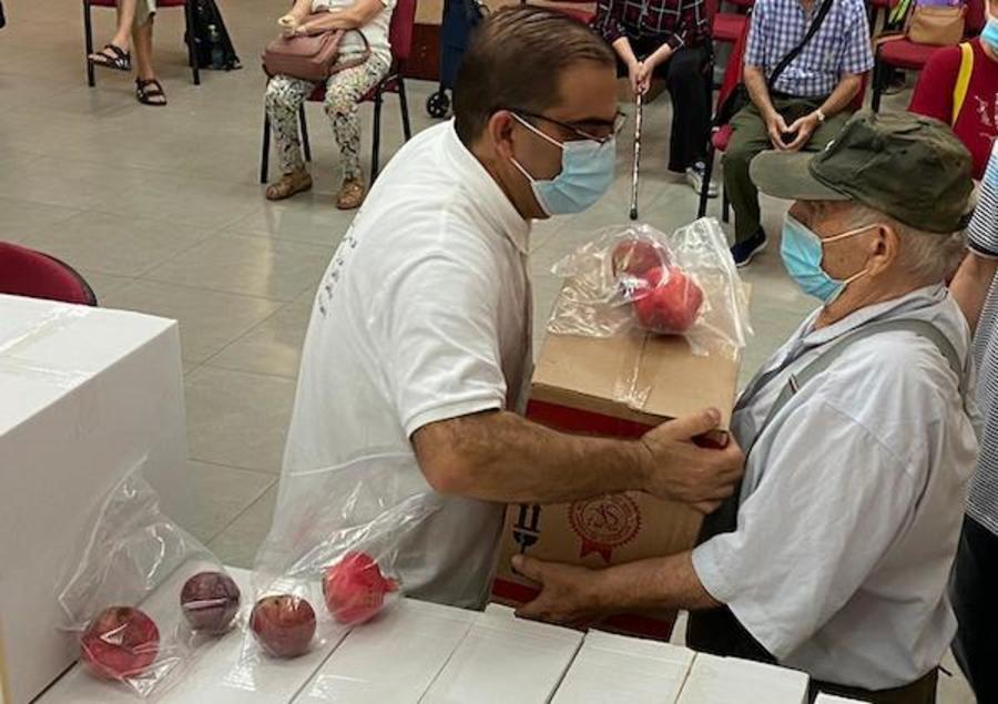 Saleem Shalash (L), an Arab pastor of Home of Jesus the King Church in Nazareth, hands a food package to a Jewish Israeli during a church outreach. (Photo: courtesy)
