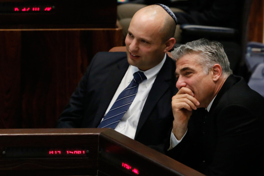 Naftali Bennett speaks with Yair Lapid in the assembly session in the plenum hall of the Israeli parliament. Photo by Miriam Alster/FLASH90