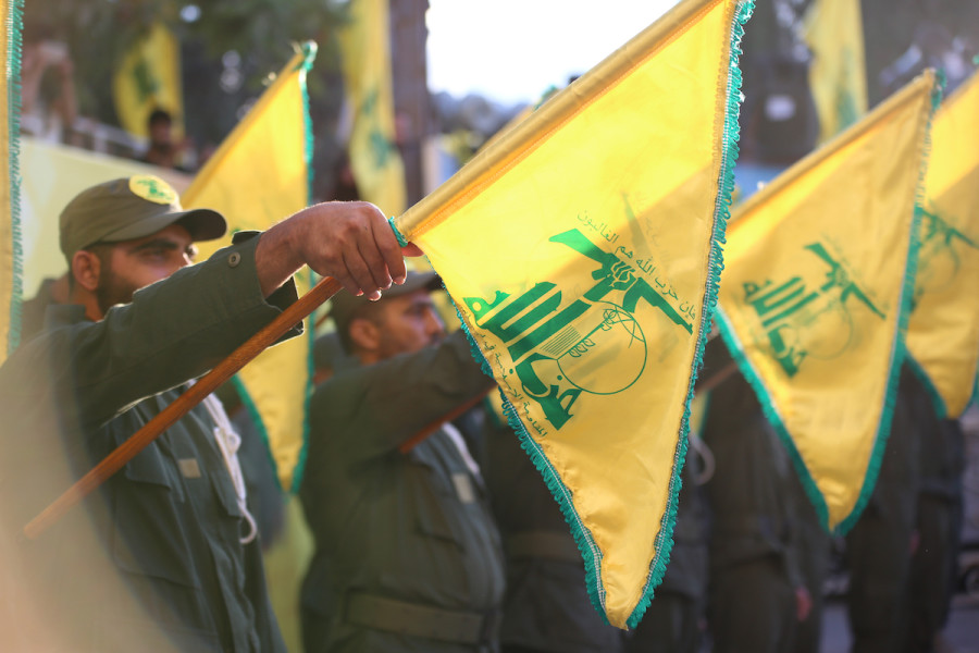Fighters holding Hezbollah flags in a military parade in southern Lebanon (Photo: Shutterstock)