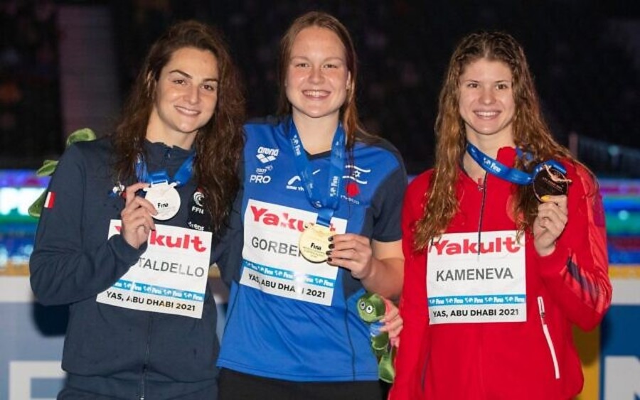 Israel's Anastasia Gorbenko (center) poses with her gold medal alongside France's silver medalist Beryl Gastaldello and Russia's bronze medalist Maria Kameneva after winning the 100-meter individual medley on December 19, 2021, at the World Swimming Championships in Abu Dhabi. (Photo: Israel Swimming Association)