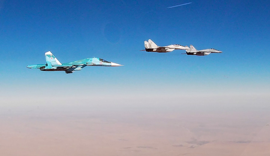 Russian Air Force Sukhoi Su-34 strike aircraft (L) and a Syrian Air Force Mikoyan MiG-29 fighter aircraft on a patrol mission, Jan. 22, 2022 (Photo: Russian Defence Ministry/TASS)