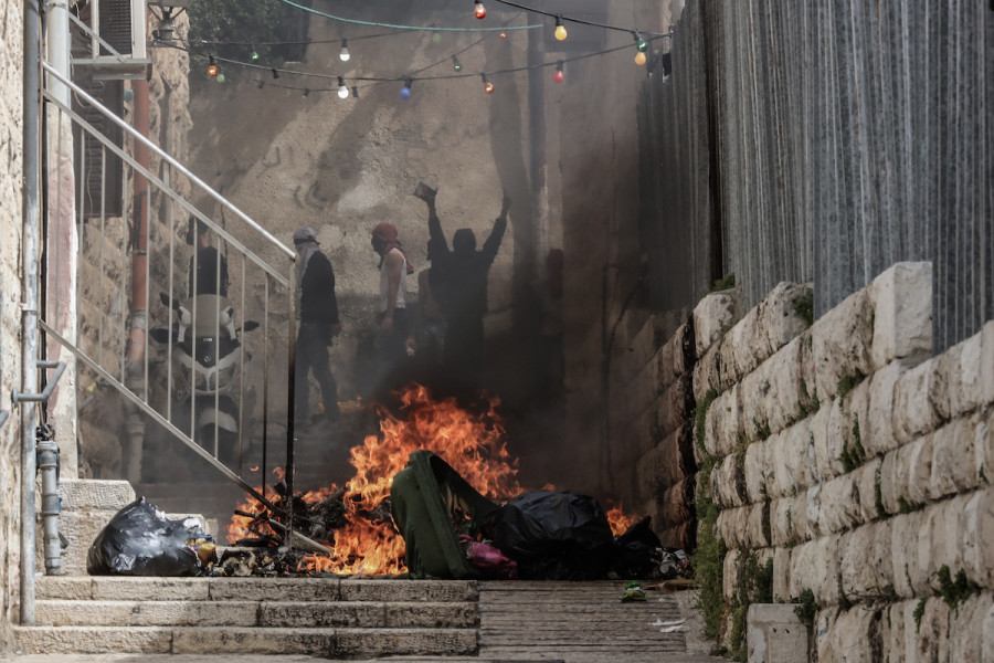Palestinians set fire to a trash bin during clashes with Israeli security forces in Jerusalem's Old City, April 17, 2022 (Photo: Ilia Yefimovich/DPA/Reuters)
