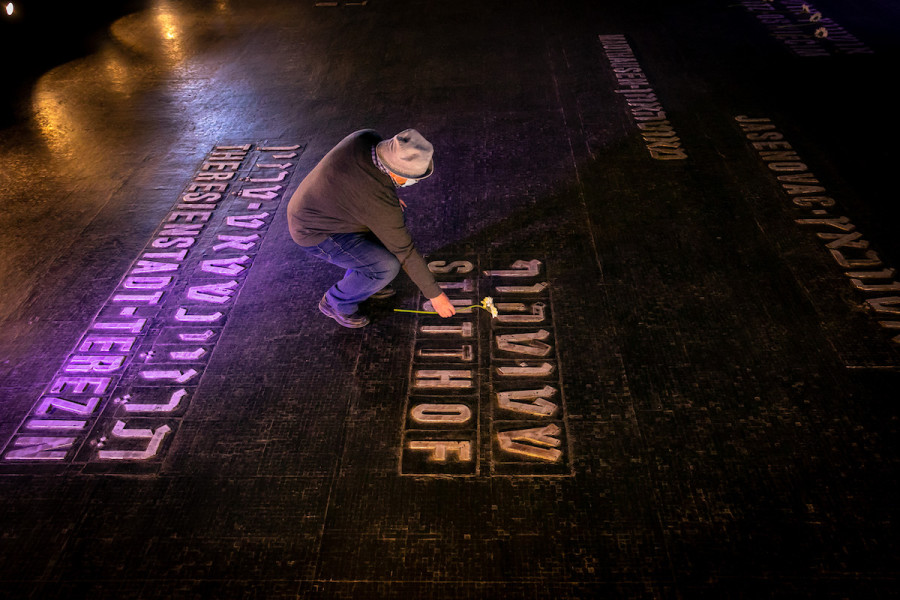 Relatives and friends of Holocaust survivors place flowers on names of concentration camps seen on the floor of the Hall of Remembrance at the Yad Vashem Holocaust Museum, on Holocaust Remembrance Day, Apr. 8, 2021. (Photo: Olivier Fitoussi/Flash90)