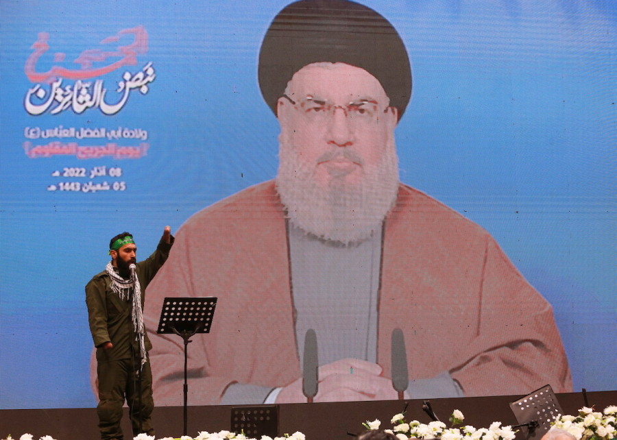 A Hezbollah member gestures before secretary-general of the organization, Sayyed Hassan Nasrallah, addresses his supporters from a screen during a rally to commemorate Hezbollah Wounded Veterans Day in Beirut's southern suburbs, March 8, 2022. (Photo: REUTERS/Aziz Taher)