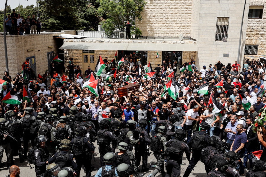 Family and friends carry the coffin of Al Jazeera reporter Shireen Abu Akleh, who was killed during an Israeli raid in Jenin in the occupied West Bank, as Israeli security forces stand guard, during her funeral in Jerusalem, May 13, 2022. (Photo: REUTERS/Ammar Awad)