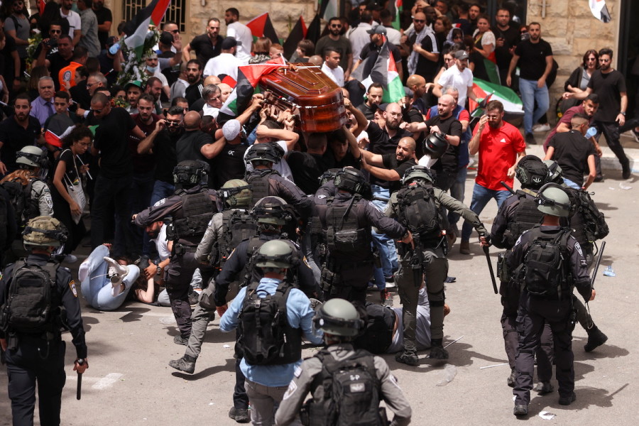 Palestinians carry the coffin of Al Jazeera reporter Shireen Abu Akleh, who was killed during an Israeli raid in Jenin, as clashes erupted with Israeli security forces during her funeral in Jerusalem, May 13, 2022. (Photo: REUTERS/Ammar Awad)