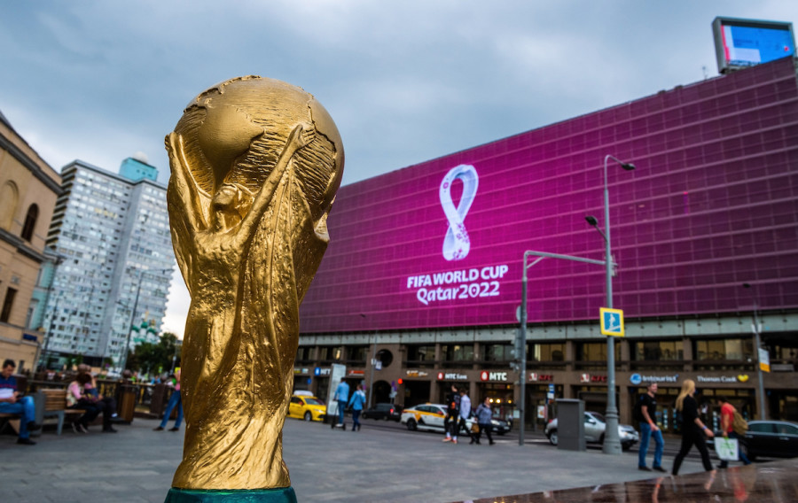 Copy of World Cup trophy on background logo of the FIFA World Cup 2022, which will be held in Qatar, on a giant screen in Moscow city center, Sep. 2019 (Photo: Screenshot)