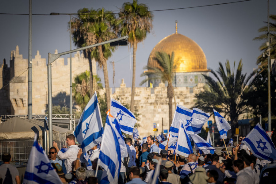 Israelis hold Israeli flags and dance during the March of Flags at the Damascus Gate in Jerusalem's Old City, June 15, 2021. (Photo: Yonatan Sindel/Flash90