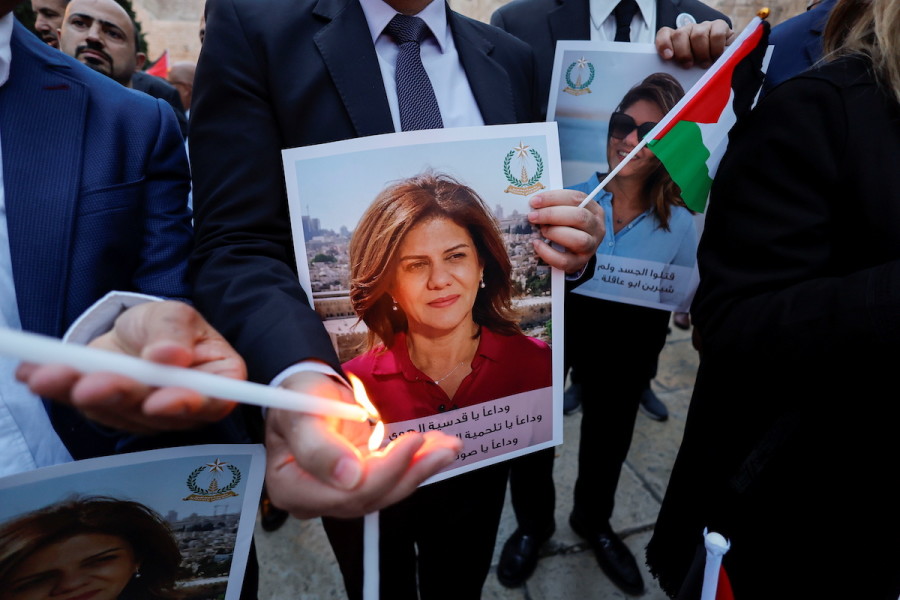 People light candles during a vigil in memory of Al Jazeera journalist Shireen Abu Akleh outside the Church of the Nativity in Bethlehem, May 16, 2022. (Photo: REUTERS/Mussa Qawasma)