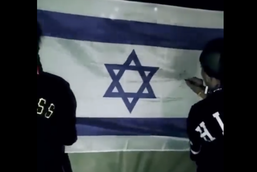 Members of the Spanish band, Tribade, deface an Israeli flag (Photo: Screenshot)