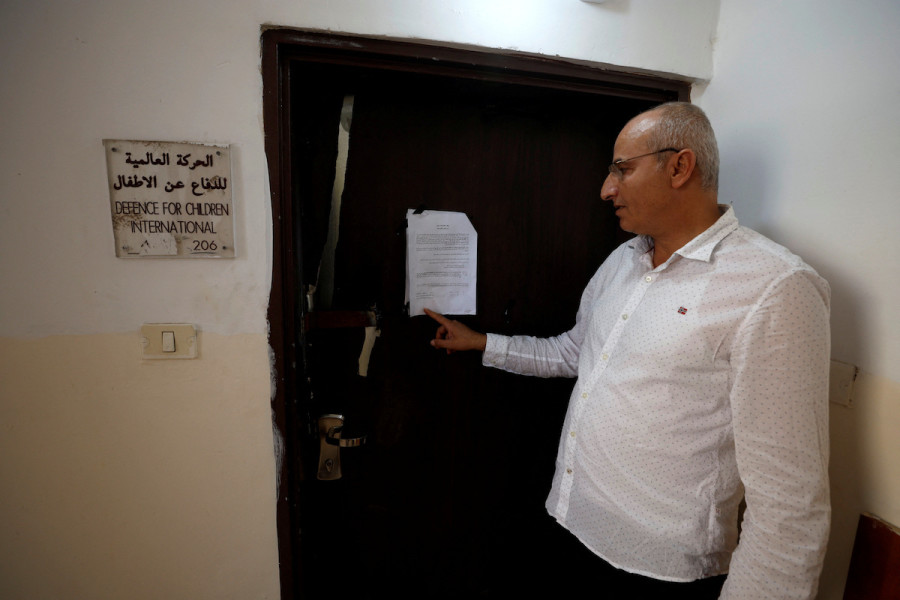 A Palestinian man stands in front of the closed entrance of the Defence For Children International, in Ramallah, August 18, 2022. (Photo: REUTERS/Mohamad Torokman)