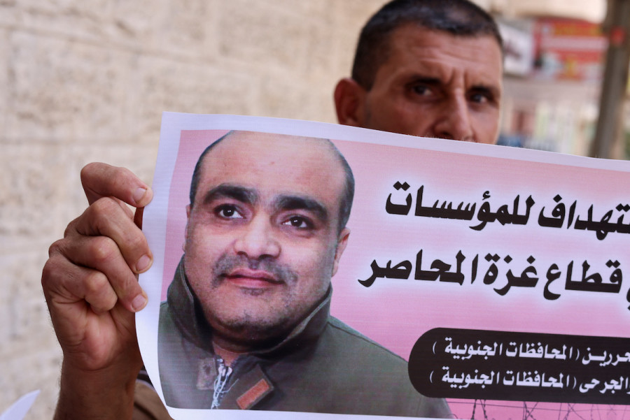 A man holds a picture of Mohammad el-Halabi, during a solidarity gathering following an Israeli court decision to sentence him for 12 years, outside the office of the International Committee of the Red Cross in Gaza City, August 30, 2022. (Photo: REUTERS/Mohammed Salem)