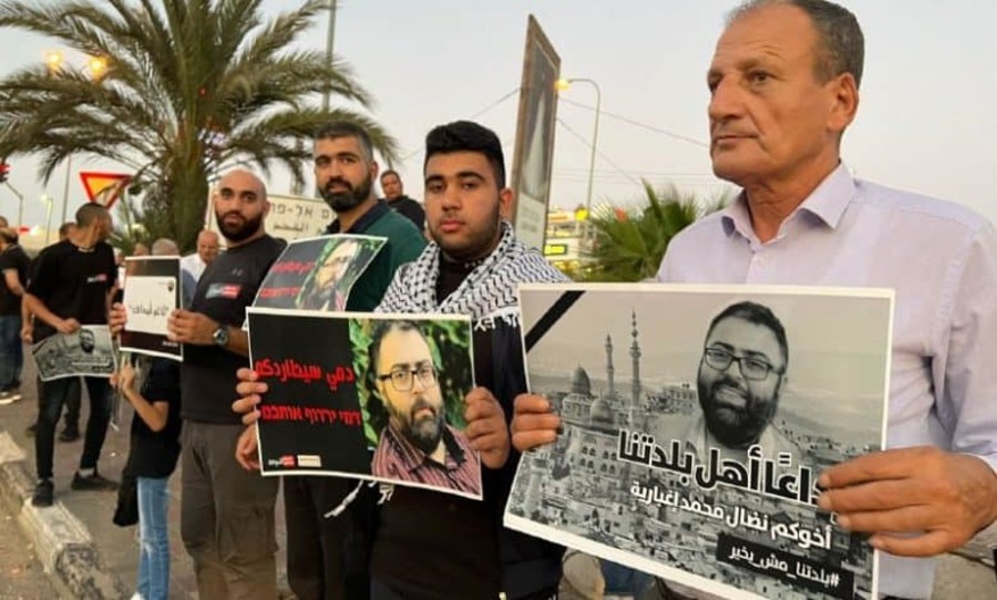 Arab Israelis hold signs with a picture of murdered journalist Nadal Ijbaria (Photo: Bldtna/Facebook)