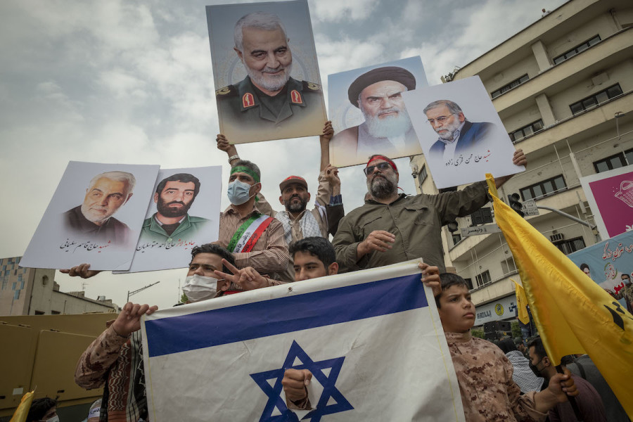 Iranian demonstrators hold up portraits of the former commander of Iran’s Islamic Revolutionary Guard Corps General Qasem Soleimani (C), Iranian Nuclear scientist, Mohsen Fakhrizadeh (R), and Iran’s Late Leader Ayatollah Ruhollah Khomeini while standing behind a torn Israeli flag during a rally commemorating the International Quds Day, also known as the Jerusalem day, April 29, 2022. (Photo: Morteza Nikoubazl/NurPhoto)