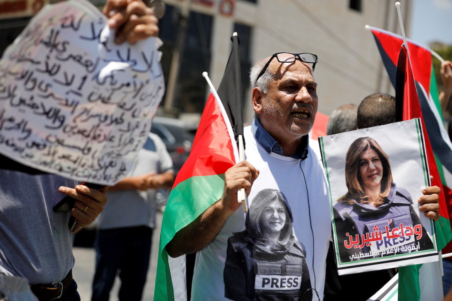 A protestor holds up a picture of journalist Shireen Abu Akleh as Palestinians demonstrate against U.S. President Joe Biden's visit to Bethlehem, July 15, 2022. (Photo: REUTERS/Raneen Sawafta)