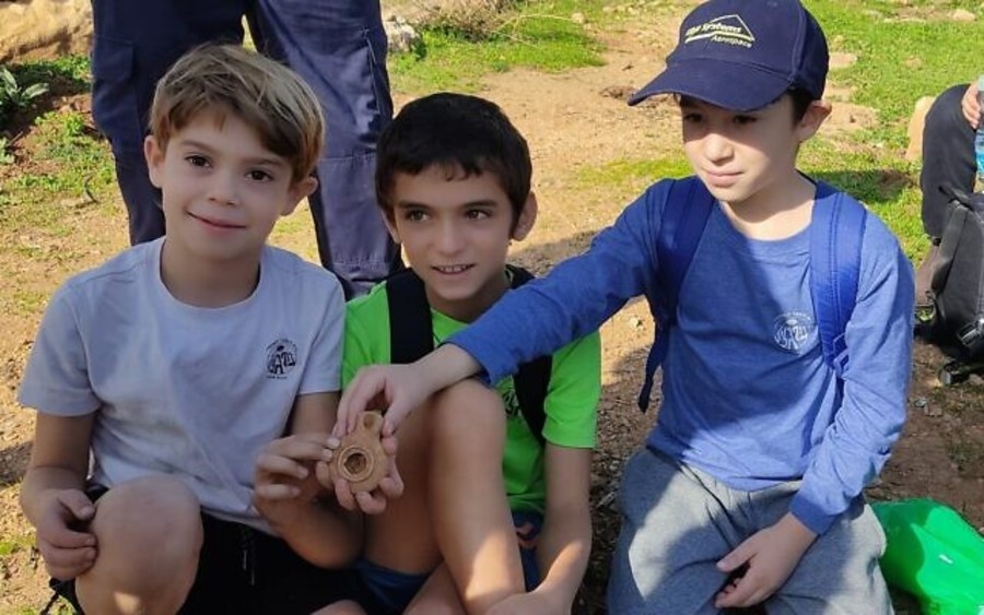 Israeli students Alon Cohen, Liam Atias, and Rotem Levnat with an ancient oil lamp they discovered in Kibbutz Parod, Dec. 2022. (Photo: Israel Antiquities Authority)
