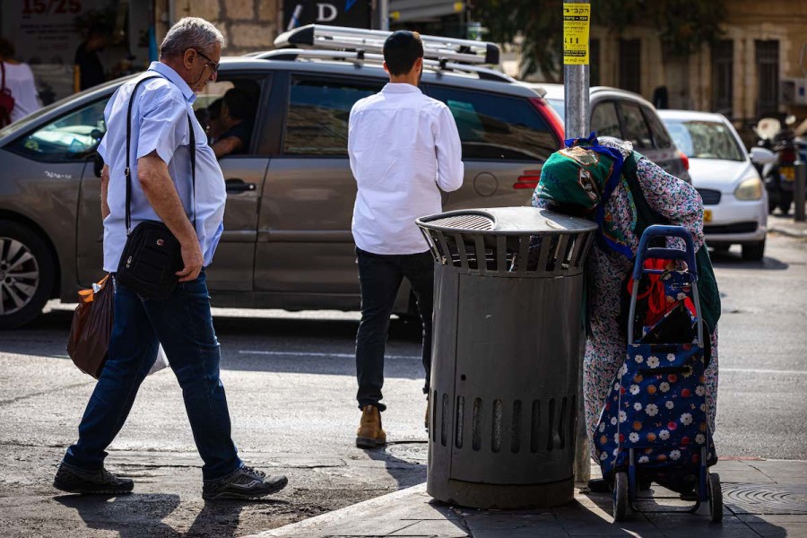 An elderly woman searches for cans in a trash can at Mahane Yehuda market in Jerusalem, Oct. 30, 2022. (Photo: Olivier Fitoussi/Flash90)