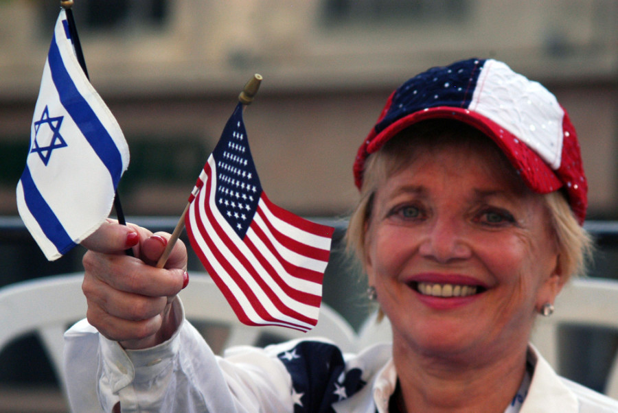 JERUSALEM-OCT 02 2007:American woman waving the flags of Israel and United States in Jerusalem March.It's a traditional procession held every year during Sukkot Jewish holiday in Jerusalem, Israel.