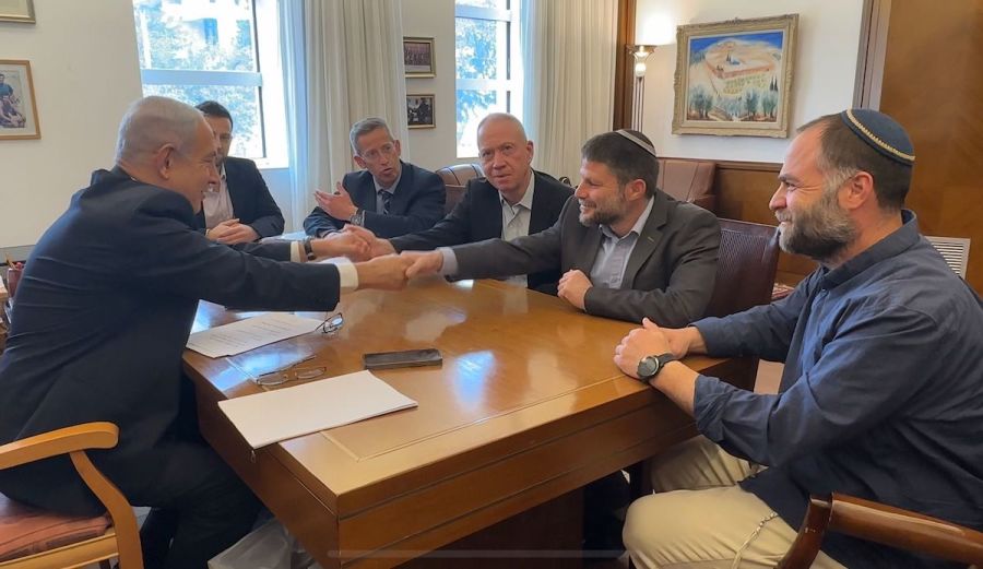 Israeli Prime Minister Benjamin Netanyahu shakes hands with Finance Minister and Minister in the Defense Ministry Bezalel Smotrich (second from right), and with Defense Minister Yoav Gallant (third from right), after they signed an agreement transferring authorities for civilian affairs in the West Bank to Smotrich. (Photo courtesy
of Office of the Finance Minister)