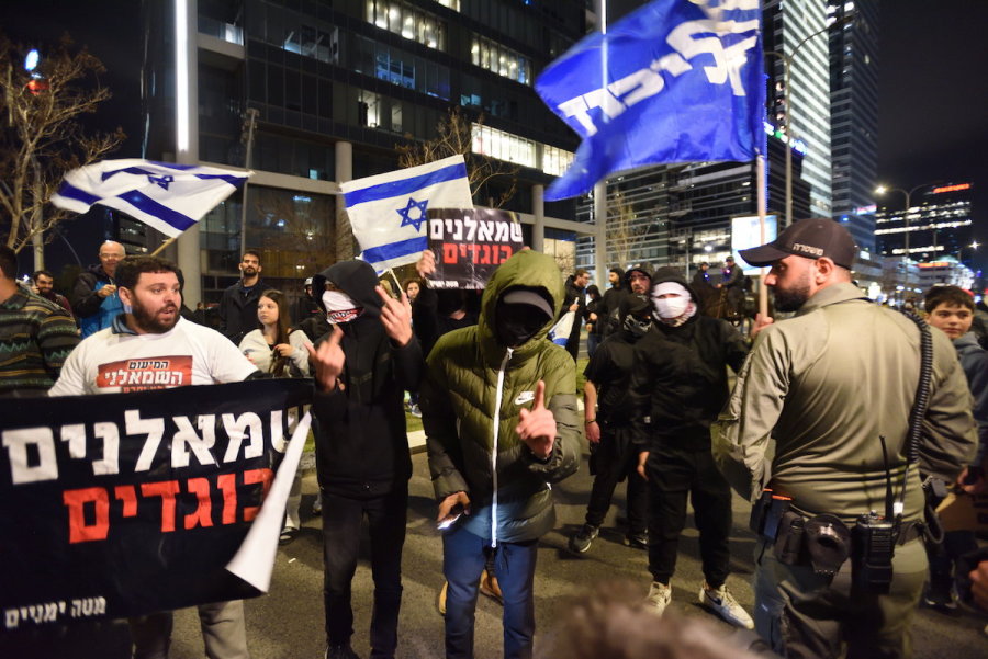 Right-wing activists – with signs reading "Lefts are traitors" – confront protesters at a rally against the Israeli government's judicial overhaul bills, in Tel Aviv, Mar. 18, 2023. (Photo: Gili Yaari /Flash90)