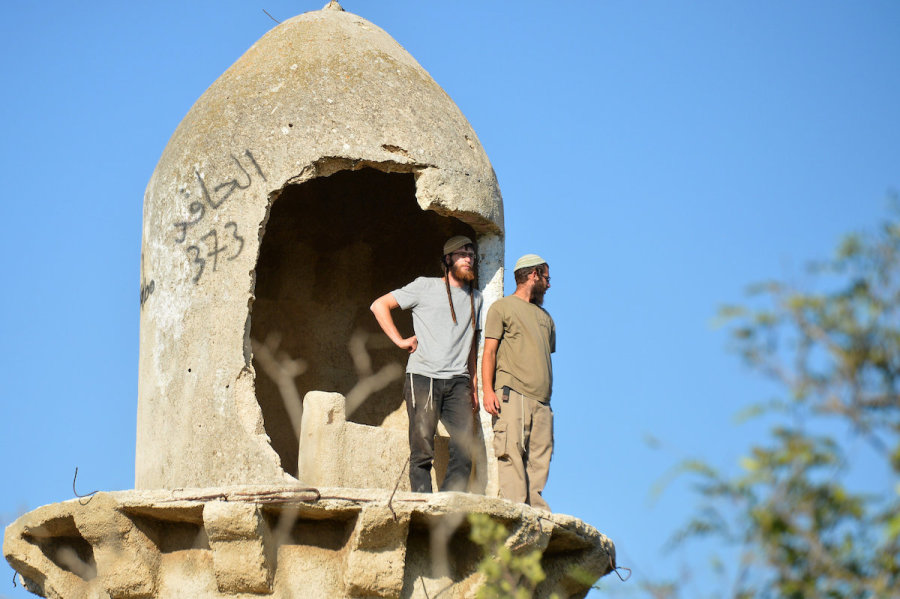 Israelis settlers stand on top on a building as they visit in what was the Sa-Nur settlement, one of four Jewish settlements in northern Samaria that was evacuated in the 2005 Disengagement, Jul. 21, 2015. (Photo: Flash90)