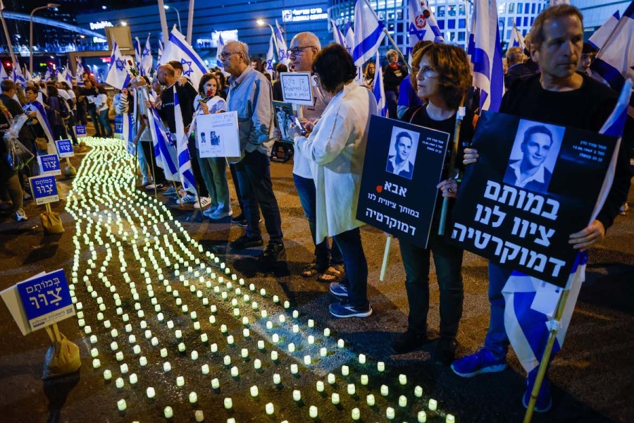 Bereaved families and Israelis stand next to memorial candles during a protest against the Israeli government's planned judicial overhaul, in Tel Aviv, Apr. 22, 2023. (Photo: Erik Marmor/Flash90)