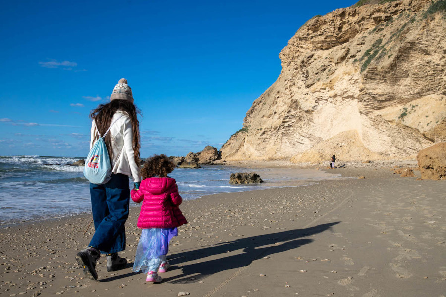 Illustrative - A woman and her child walking along the Mediterranean coast in Israel, Jan. 21, 2021. (Photo: Yossi Aloni/Flash90)