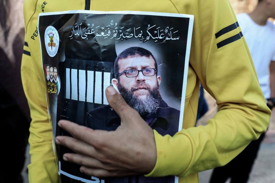 A man holds a poster of the Palestinian Islamic Jihad leader Khader Adnan, following the announcement of his death after 86 days of hunger strike at Israeli prison. (Photo: Ayman Nobani/DPA via Reuters)