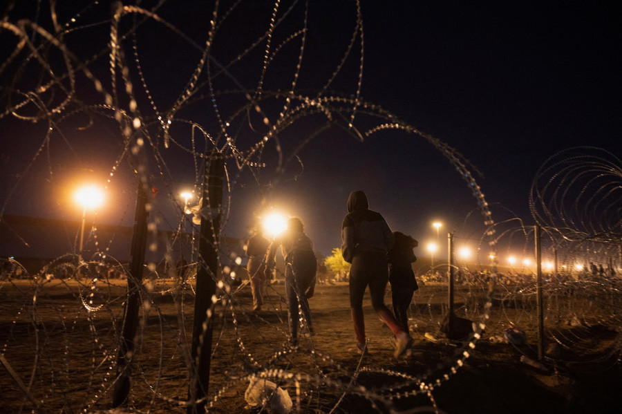 Migrants walk past a hole in a concertina wall as the United States prepares to lift COVID-19 era Title 42 restrictions that have blocked migrants at the U.S.-Mexico border from seeking asylum since 2020, near El Paso, Texas, May 10, 2023. (Photo: REUTERS/Stringer)