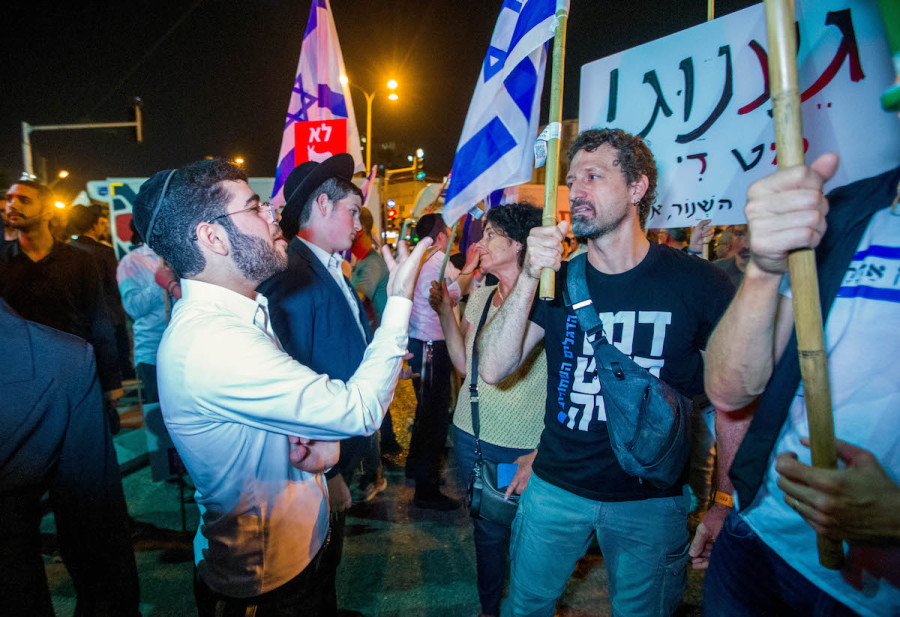 Demonstrators argue with ultra-Orthodox Jews during a protest march in Bnei Brak, against the billions in funds provided to ultra-Orthodox parties in the state budget, May 17, 2023. (Photo by Flash90)