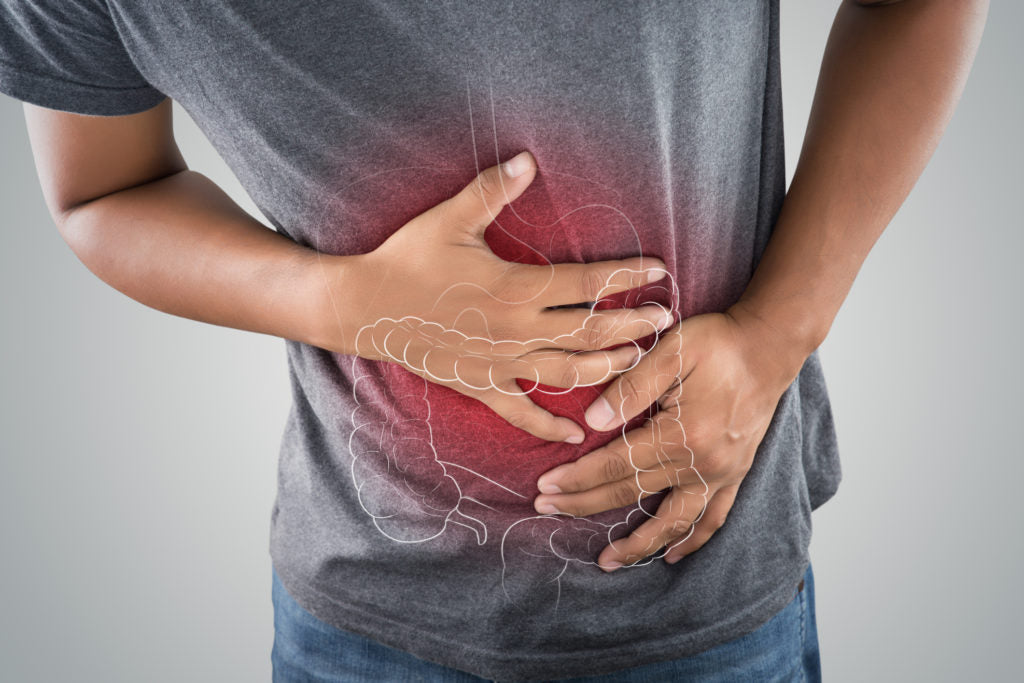Man holding his stomach in pain | HealthMasters