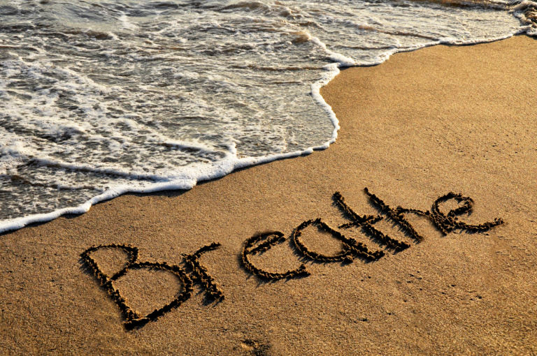 The word breathe written in sand on the beach | HealthMasters