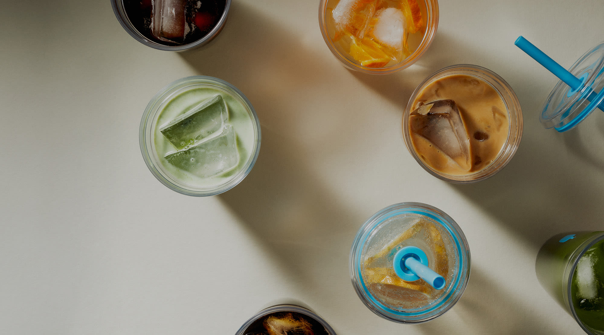 Image of Clear Cold Tumblers from above, showing several different prepared iced beverages in a colorful manner