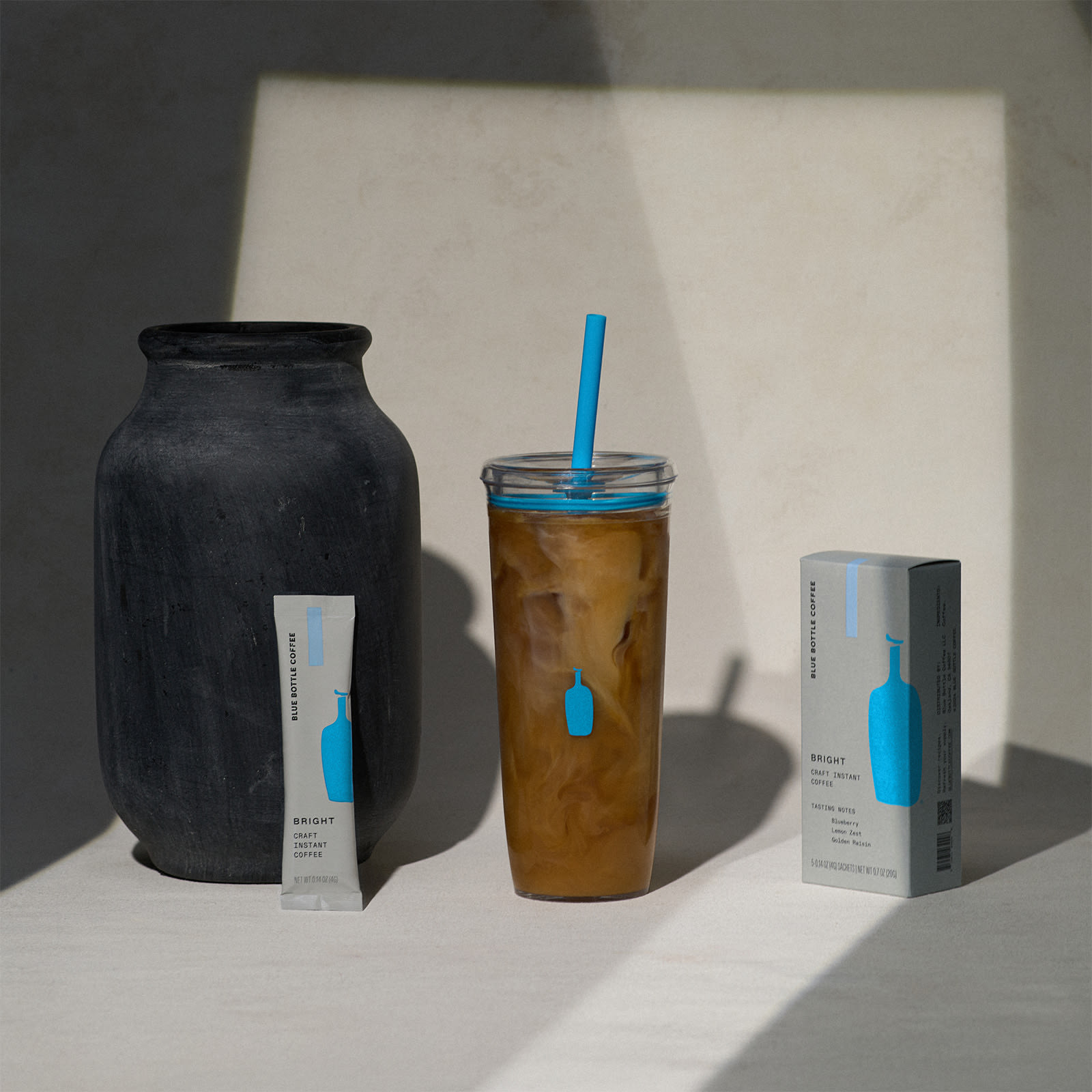 Image of Clear Cold Tumbler with the lid and blue straw off and set to the side. The cup is showing the Blue Bottle Coffee logo